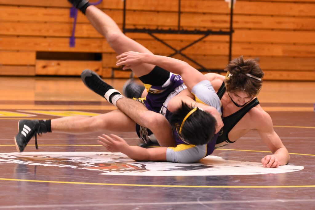Wrestler landing a takedown in competition