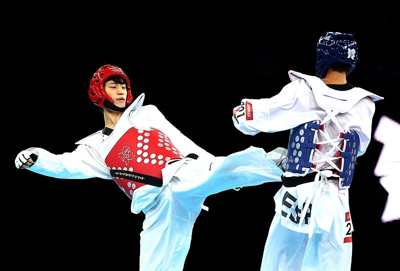 Taekwondo contestant landing a roundhouse kick to the body