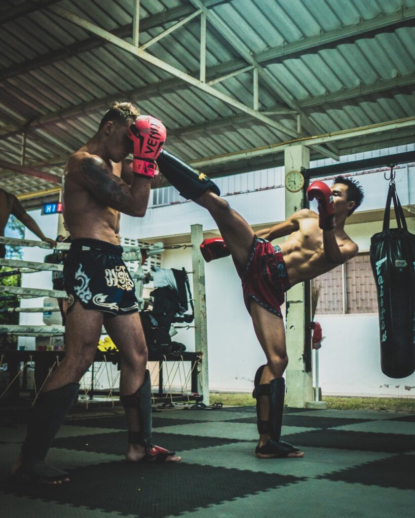 Muay Thai practitioner landing a head kick on his sparring partner